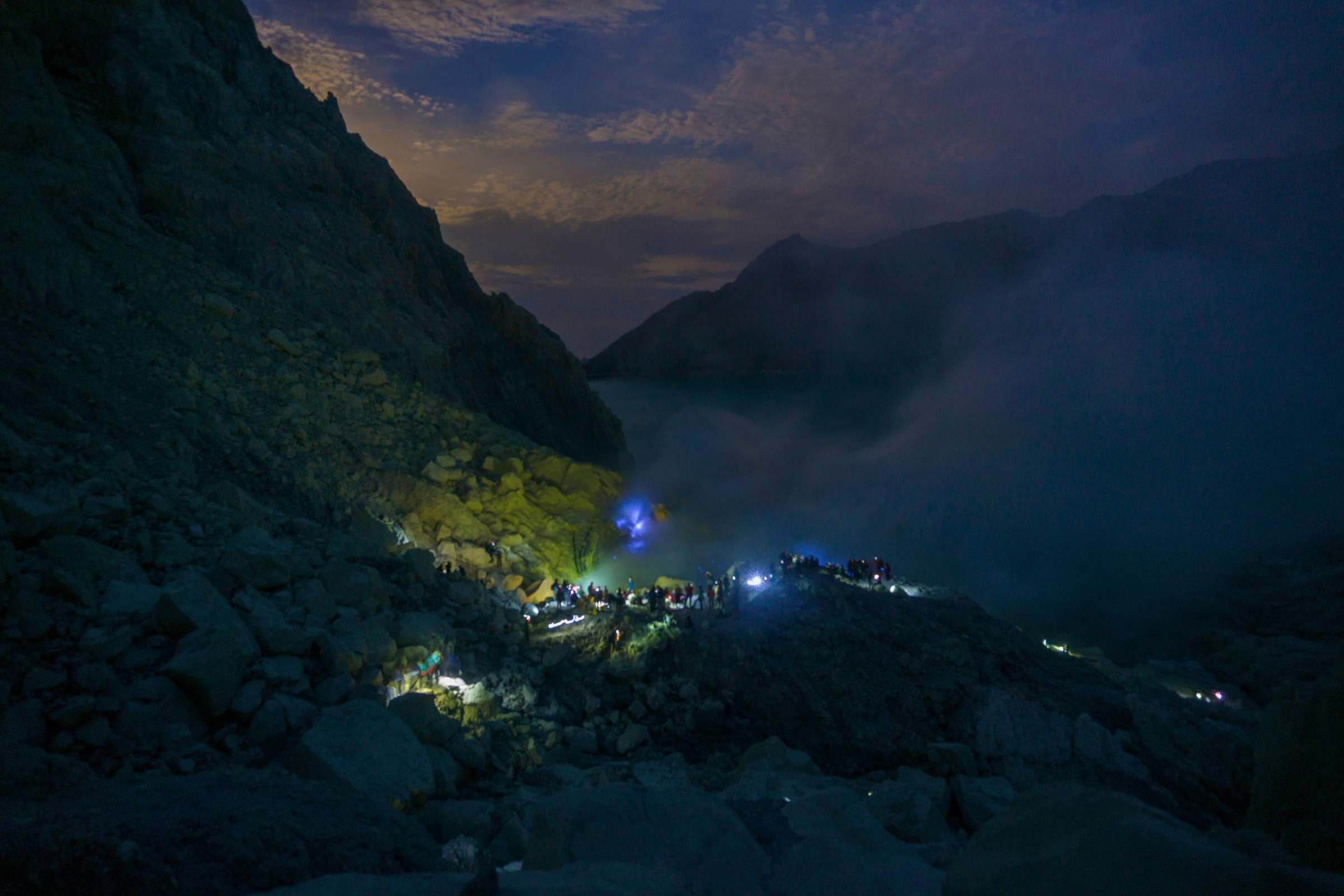 hikers trekking mount ijen at night with headlamps
