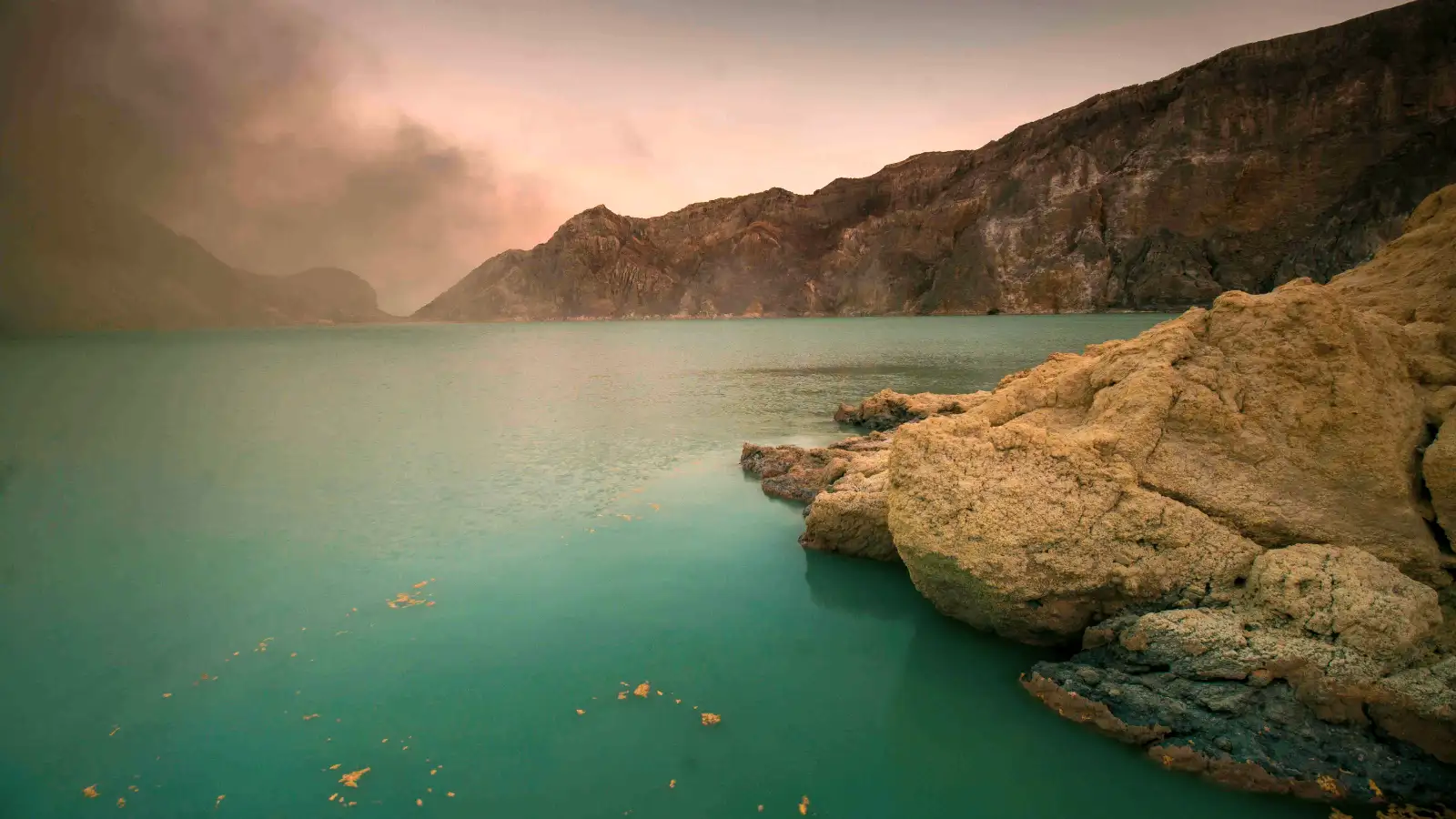 Sulfur Deposits and Acidic Water The contrast between the yellow sulfur deposits and the turquoise acidic water at Ijen Crater